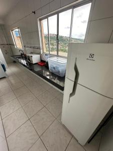 cocina con nevera en una habitación con ventanas en Apart 2 quartos Ribeiro, en Belo Horizonte