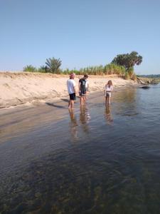 three people standing in the water on a beach at King of love in Luxor