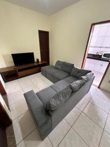 sala de estar con sofá y TV de pantalla plana en Apart 2 quartos Ribeiro, en Belo Horizonte