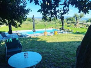 een zwembad met een tafel, stoelen en parasols bij Terre Luberon in Pertuis