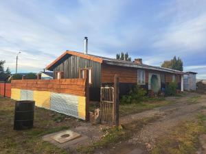 una casa con una valla colorida delante de ella en Hostal y Viajes Balmaceda, 