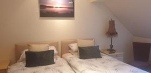 1 dormitorio con 2 camas con almohadas en Culag Lochside Self Catering, en Luss