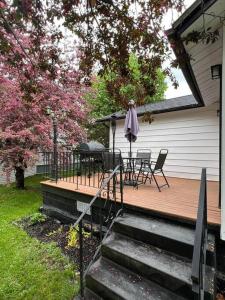 a wooden deck with a table and an umbrella at Cozy chalet near the beach in Shediac