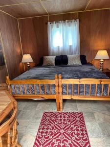 a bedroom with a large wooden bed with two lamps at Cozy chalet near the beach in Shediac