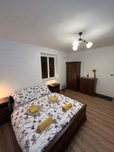 a bedroom with a large bed with yellow pillows on it at Sládkovičov dvor in Banská Štiavnica