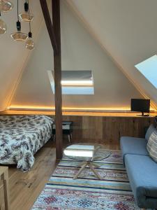a attic room with a bed and a couch at Les Magniolas in Prilly