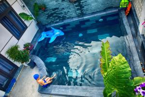 a swimming pool with a dolphin in the water at Hoi An Garden Sea Homestay in Hoi An