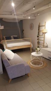 Un dormitorio con una cama, un sofá y una mesa. en Appartement - centre historique, en Morlaix