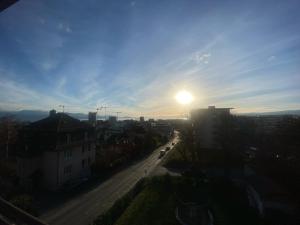 una vista de una ciudad con el sol en el cielo en Les Magniolas en Prilly