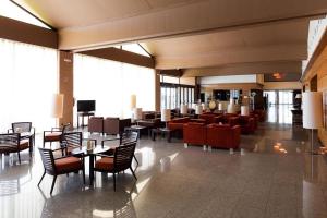 um átrio com mesas e cadeiras num edifício em HOTEL PUERTA DE SAHAGUN em Sahagún