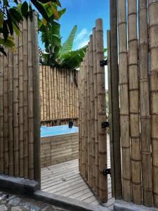 um portão de madeira com uma piscina ao fundo em Ibuku Hotel Guatapé - Chalets em Guatapé