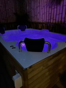 瓜塔佩的住宿－Ibuku Hotel Guatapé - Chalets，客房内的按摩浴缸配有紫色照明