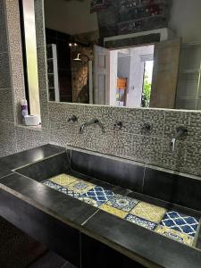 瓜塔佩的住宿－Ibuku Hotel Guatapé - Chalets，浴室水槽设有2个水龙头和镜子