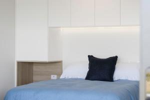 Una cama con una almohada negra encima. en Pukehina Estuary Sunset Views Studio, en Pukehina