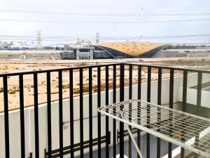 a table on a balcony with a view of a building at Modern Apartment Steps Away from Metro Access in Dubai