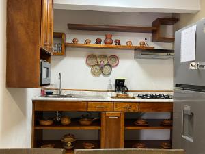 a kitchen with a sink and a refrigerator at Teoti Querido in San Sebastian Xolalpa