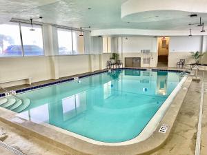 a large swimming pool with blue water in a building at Sunset Studio Daytona Beachfront in Daytona Beach