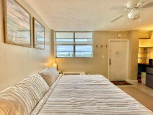 a large bed in a room with a window at Sunset Studio Daytona Beachfront in Daytona Beach