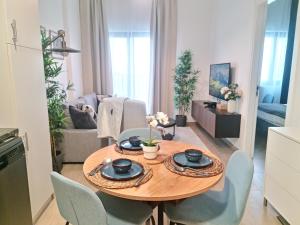 a kitchen and living room with a wooden table and chairs at Modern Apartment Steps Away from Metro Access in Dubai