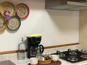 a kitchen counter with a coffee maker and plates on the wall at Teoti Querido in San Sebastian Xolalpa