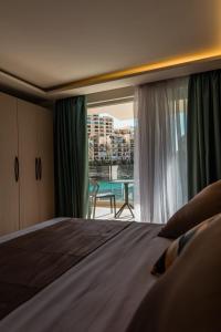 a bedroom with a bed and a view of a balcony at Blu Waters Boutique Hotel in Xlendi +36 photos