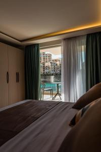 a bedroom with a bed and a view of a balcony at Blu Waters Boutique Hotel in Xlendi