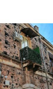 een raam aan de zijkant van een bakstenen gebouw bij TheRoom in Catania