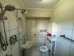 a small bathroom with a toilet and a sink at Advantage Apartments Curacao in Willemstad