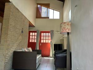 sala de estar con puerta roja y pared de ladrillo en Advantage Apartments Curacao, en Willemstad
