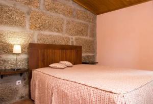 een slaapkamer met een bed en een bakstenen muur bij Casa de Andrães Magnolias in Marco de Canavezes