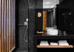 Baño negro con lavabo y ducha en Hotel MyPalace León en León