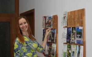 a woman is holding up a display of magazines at Pension Erholung in Bad Elster