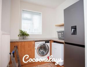 a kitchen with a washer and dryer on a counter at Cocoonstays Short Lets and Serviced Accommodation Luton in Luton