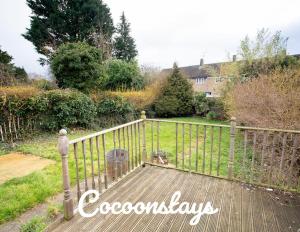 a wooden walkway leading into a yard with a fence at Cocoonstays Short Lets and Serviced Accommodation Luton in Luton