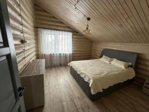 1 dormitorio con cama y techo de madera en Бозайгыр en Kuprinka