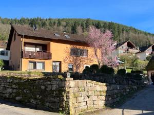 a house with a stone fence and a stone wall at Viva la Wildbad in Bad Wildbad