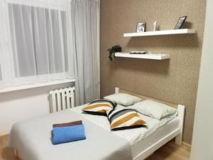 a small bedroom with a bed with two pillows at Apartament Szept Plaży in Kołobrzeg