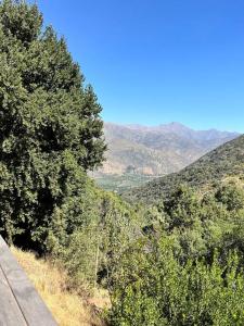 Blick auf einen Hügel mit Bäumen und Bergen in der Unterkunft Cabaña ecológica y aislada in Santiago