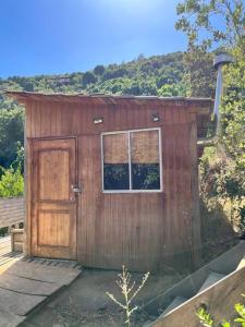 een houten schuur met een deur en een raam bij Cabaña ecológica y aislada in Santiago