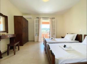 a hotel room with three beds and a window at Alexandra's Apartments by Exclsv in Sidari