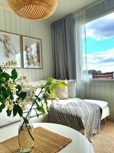 a room with a bed and a vase of flowers at Stuga med havsutsikt in Robertsfors