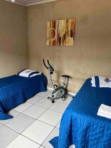 a room with two beds and a treadmill in it at Casa de praia p/ família, confortável, bem arejada in Serra