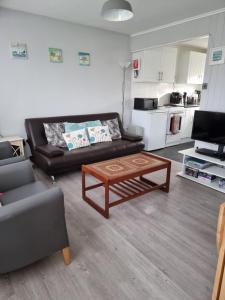a living room with a couch and a coffee table at Sands Holiday Chalet Dog friendly, free wifi, swimming pool and club passes included in Scratby +30 photos
