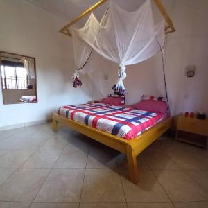 a bedroom with a bed with a canopy at Bukoto Private Room in Kampala