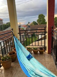 a blue hammock on a balcony with potted plants at Bukoto Private Room in Kampala