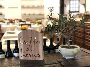 uma mesa com garrafas de vinho e um sinal que lê café todos os vivos em FORESTERIA GUESTHOUSE CA' DEI BACHITT em Lierna