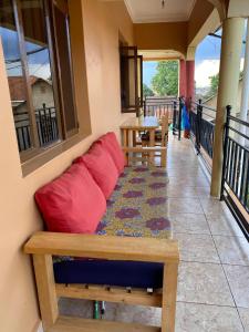 a couch on a balcony with a table and chairs at Bukoto Private Room in Kampala