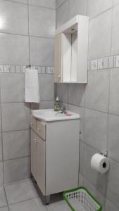 uma pequena casa de banho branca com um lavatório e um espelho. em Casa de Campo em Bento Gonçalves em Bento Gonçalves