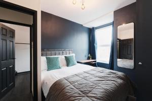a bedroom with a large bed and a mirror at Lamara Flat 1, Liverpool in Liverpool