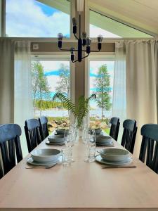 a dining room table with chairs and a large window at Stuga med havsutsikt in Robertsfors